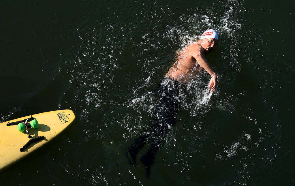 At the start of his shift, Jim Boyce, 65, the supervising lifeguard at Healdsburg Veterans Memorial Beach, swims several hundred yards after using his rescue board to paddle a mile in the Russian River, Thursday, July 20, 2023. (Kent Porter / The Press Democrat)
