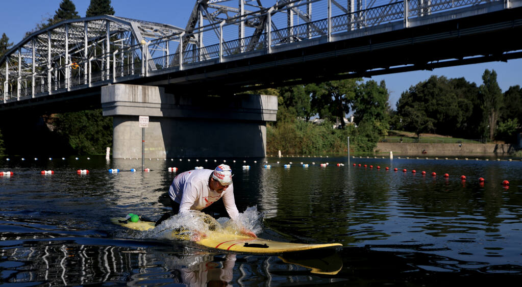 Jim Boyce, 65, the supervising lifeguard at Healdsburg Veterans Memorial Beach, paddles back in to shore after practicing his rescue skills on the Russian River, Thursday, July 20, 2023. (Kent Porter / The Press Democrat)