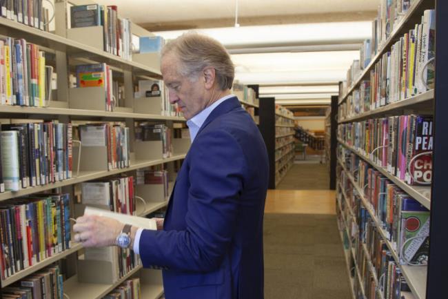 FILE - Nate Coulter, executive director of the Central Arkansas Library System (CALS), looks at a book in the main branch of the public library in downtown Little Rock, Ark., on May 23, 2023. Arkansas is temporarily blocked from enforcing a law that would have allowed criminal charges against librarians and booksellers for providing “harmful” materials to minors, a federal judge ruled Saturday, July 29. (AP Photo/Katie Adkins, File)