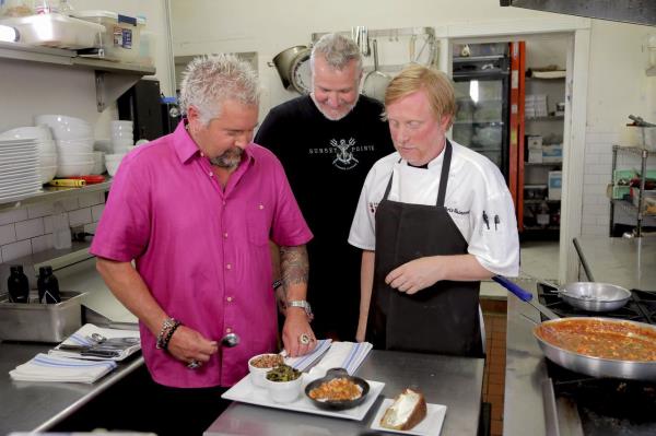 Guy Fieri, host of "Diners, Drive-Ins and Dives," left, and guest "Panini Pete" Blohme, center, spend time in the kitchen with with Chef Chris Rainosek of The Noble South in Mobile, Ala. (Courtesy of the Food Network)