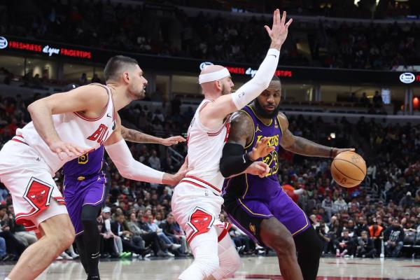 Lakers forward LeBron James dribbles as Bulls guard Alex Caruso and center Nikola Vu?evi? defend in the second half Wednesday, Dec. 20, 2023, at the United Center. 
