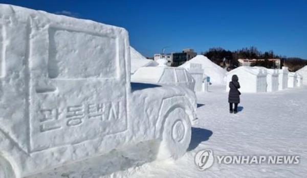 In this file photo, a visitor looks at ice sculptures at the venue of the Daegwallyeong Snow Festival in Pyeongchang, Gangwon Province, on Feb. 6, 2022. (Yonhap)