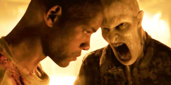 Will Smith as Robert Neville with his head down as a vampire screams at him.