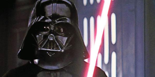 David Prowse (with James Earl Jones) as Darth Vader holding his red lightsaber in Star Wars