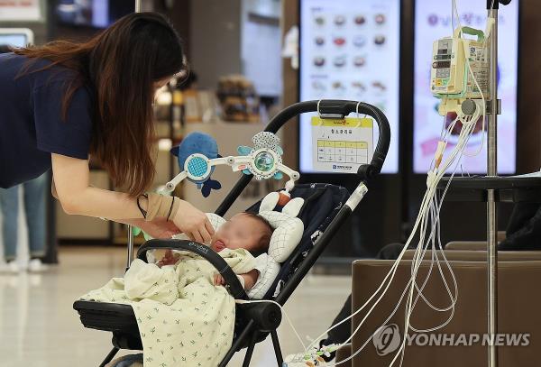 A mother takes care of her baby at a hospital in Seoul on March 24, 2024. (Yonhap)
