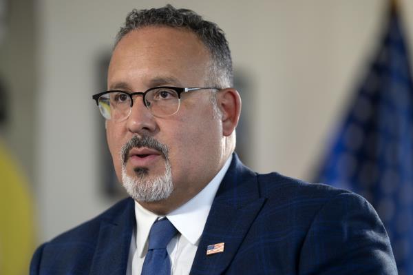 FILE - Education Secretary Miguel Cardona speaks during an interview with The Associated Press in his office at the Department of Education, Sept. 20, 2023, in Washington. The Biden administration is asking America's colleges to renew their efforts to make campuses more racially diverse, urging schools to boost scholarships and minority recruiting and to give “meaningful consideration” to the adversity students face because of their race or finances. (AP Photo/Mark Schiefelbein, File)