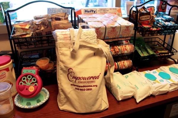 Empowered staff prepare a tote bag full of baby diapers and wipes for a client.