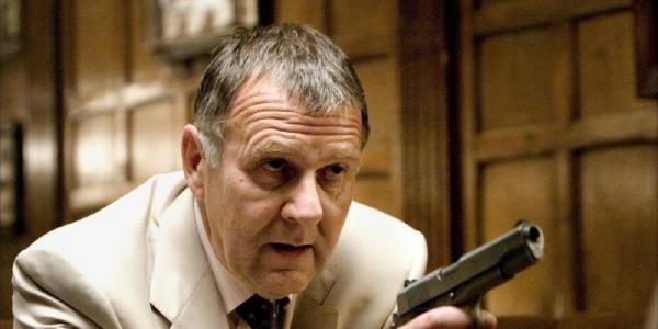 Carmine Falcone points a gun at Bruce Wayne in Batman Begins