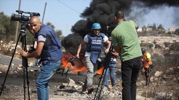 In this undated photo, Palestinian journalists cover an Israeli attack at a location in Gaza, Palestine. (AA Photo)