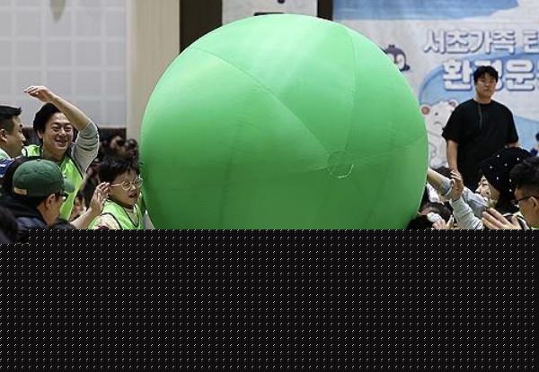 Children play with a giant balloon during an event promoting zero-carbon emissions in southern Seoul, in this file photo taken Dec. 10, 2023. (Yonhap)