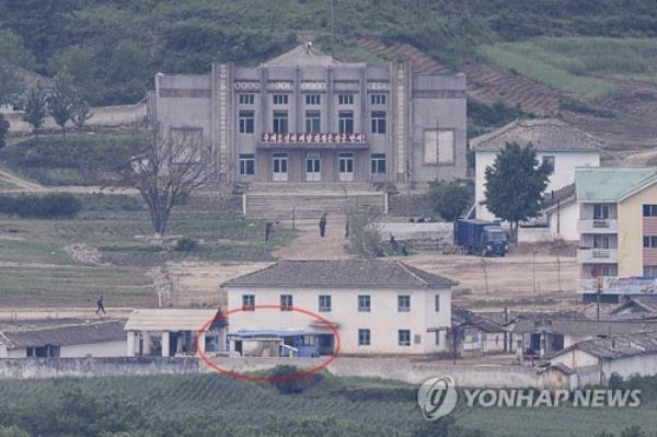 This file photo, taken May 30, 2023, from South Korea's border city of Paju, 37 kilometers northwest of Seoul, shows buses (circled red), presumed to be used at the Kaesong Industrial Complex, parked at a nearby North Korean border town. (Yonhap)